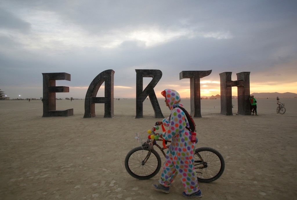 A participant walks past an art installation as approximately 70,000 people from all over the world gather for the 30th annual Burning Man arts and music festival in the Black Rock Desert of Nevada, U.S.